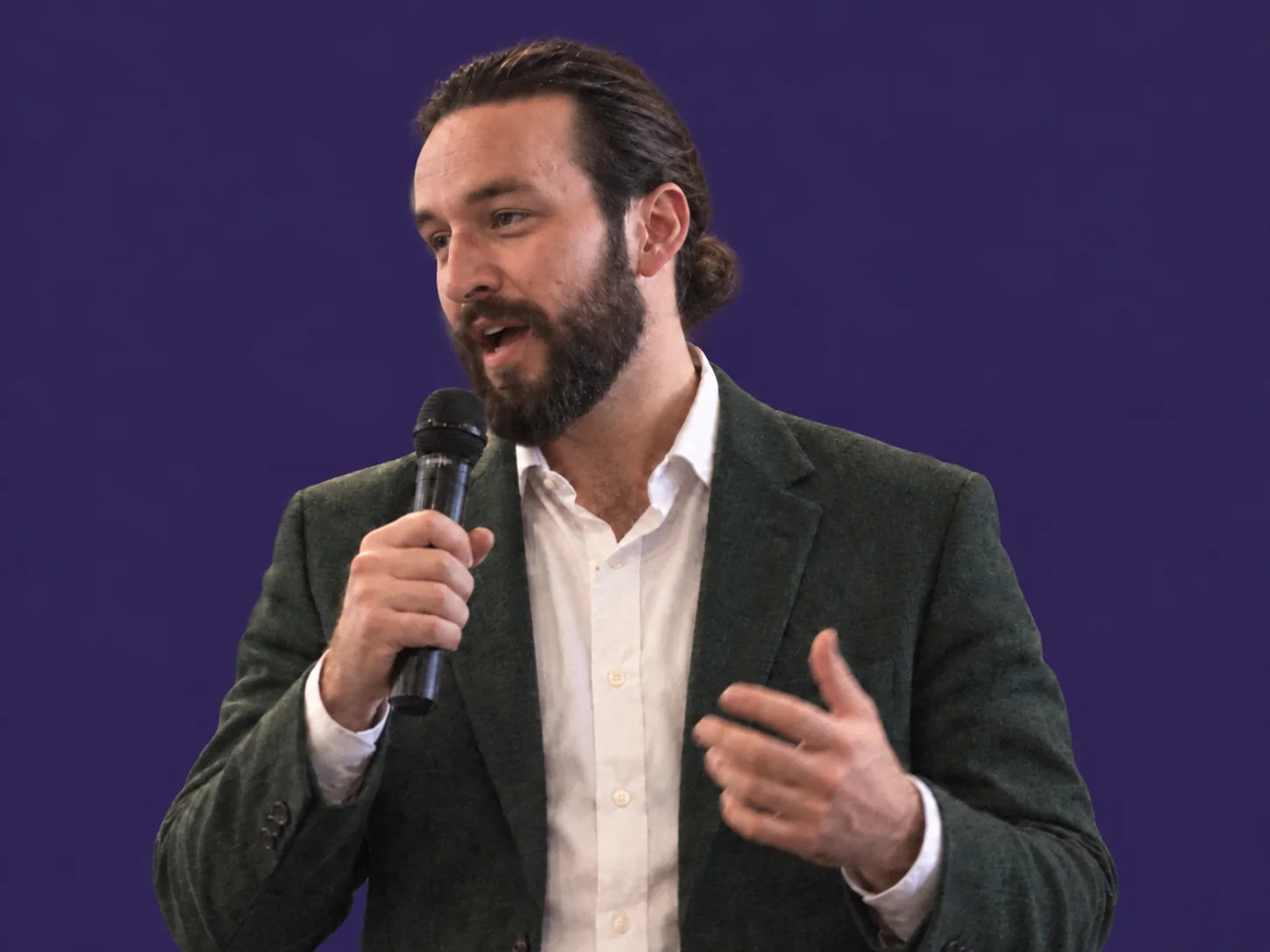 Kole Wright tenant un microphone et prenant la parole.